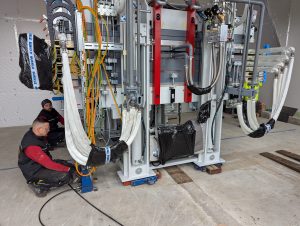 2 Mitarbeiter der Firma BÜRKLE bringen das Herzstück des Laminators genau an die vorgesehene Stelle im neuen Labor des ISC Konstanz